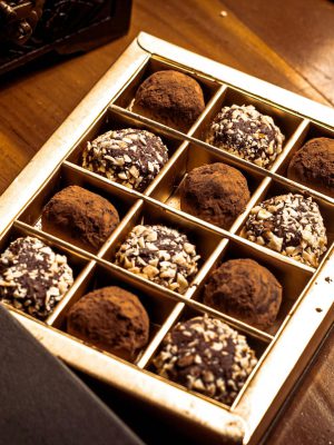 A gourmet selection of chocolate truffles in an elegant box, perfect for indulgence.