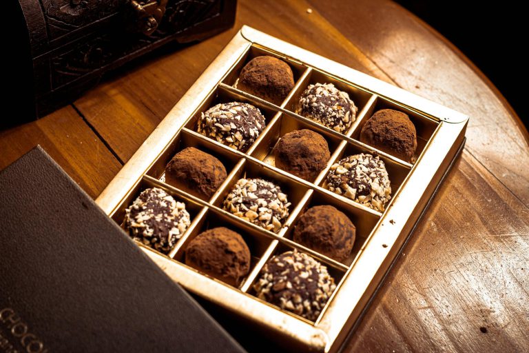 A gourmet selection of chocolate truffles in an elegant box, perfect for indulgence.