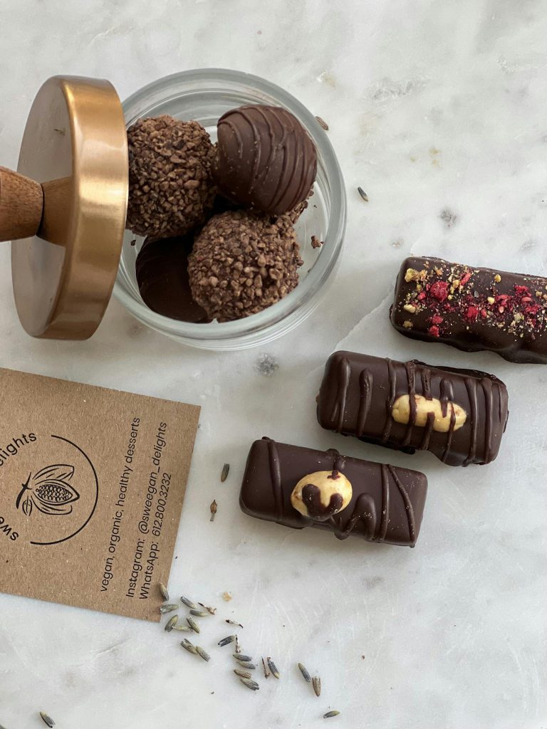 Elegant display of assorted chocolate truffles and bars with natural decor.