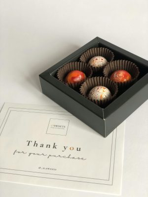 Elegant gift box of gourmet chocolates with thank you card.